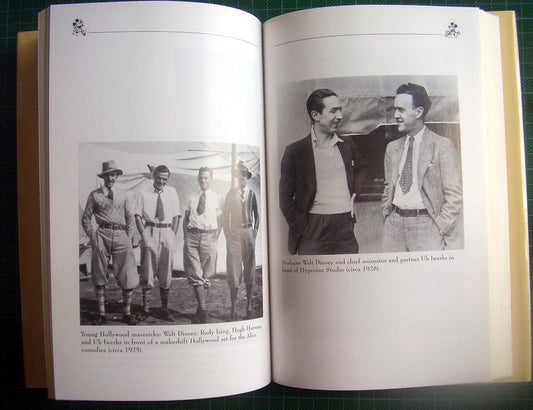 An open book showing two printed pages with black-and-white photographs and captions, photographed from above on a green grid surface.