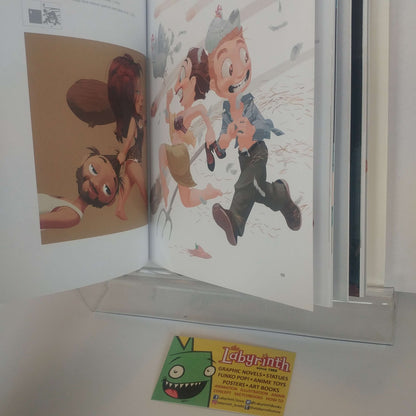 An open art book or comic volume displayed on a clear acrylic stand, showing illustrated pages with cartoon characters. A small card for 'Labyrinth' is visible in front of the book.