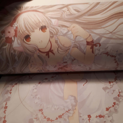 A close-up of printed artwork featuring an anime-style girl with long pale blonde hair, large brown eyes, and a white dress with red ribbon details, shown on a printed surface. from chobits your eyes only artbook