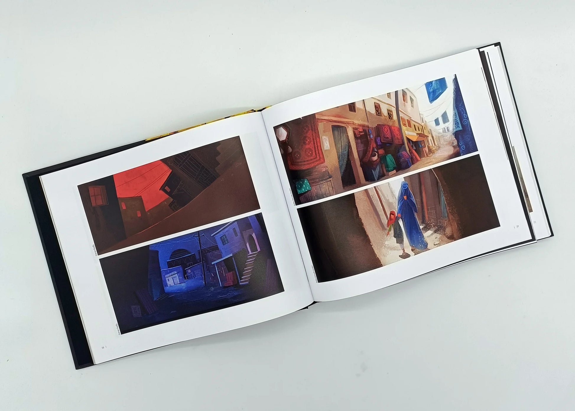 Inside pages of "Art of The Breadwinner" hardcover book displaying vibrant environmental concept art and scenes from the animated film's storyworld.