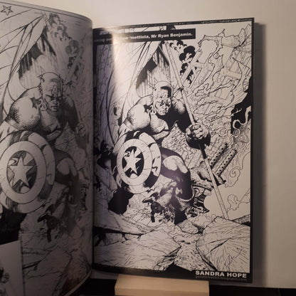 An open black-and-white illustrated book or comic page spread, showing a detailed comic-style action scene with Captain America and other characters. The right page has the text 'SANDRA HOPE' at the bottom.