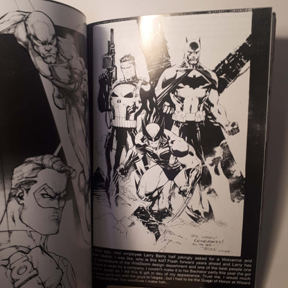 An open art book or comic-style print showing black-and-white illustrated superhero characters on the pages, photographed from above with a bright glare near the top center.