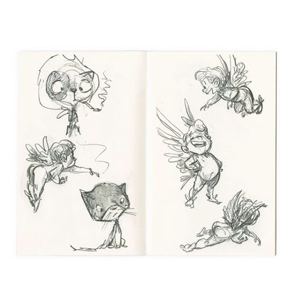 An open sketchbook displaying hand-drawn character designs, including winged fairies and a cat, in dark ink on off-white paper.