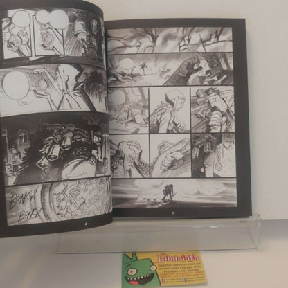 An open black-and-white comic book or art booklet displayed on a clear acrylic stand against a white wall. The pages contain multiple illustrated panels in a monochrome comic-style drawing.