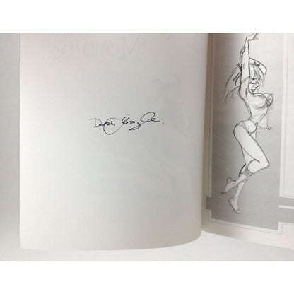 An open book or printed booklet showing a white left page with a black signature and a gray right page with a black-and-white sketch of a woman in a pose.