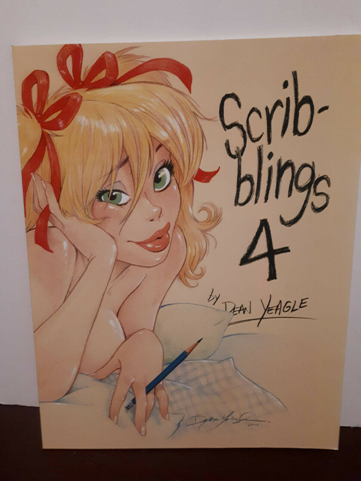 Cover of 'Scribblings 4' sketchbook by Dean Yeagle, featuring a color illustration of a female character with red hair and a red bow, in a relaxed pose with a writing instrument.