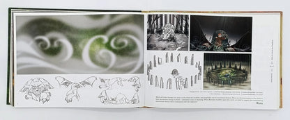Open book showing illustrations of a fantasy scene with trees and characters.
