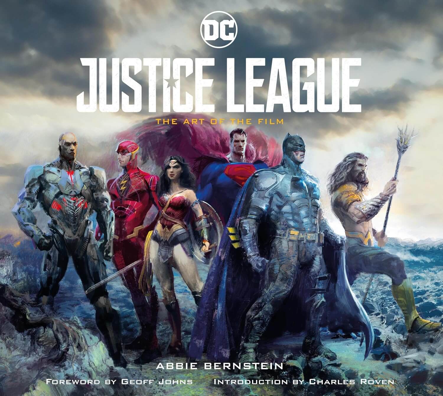Book cover of 'Justice League: The Art of the Film' featuring superhero characters against a stormy sky.