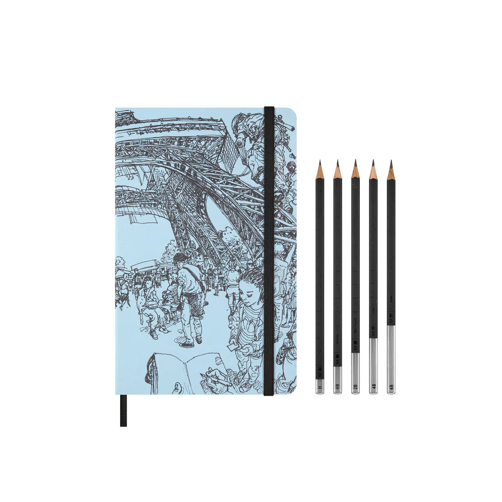 Notebook with Eiffel Tower illustration and five pencils on a white background
