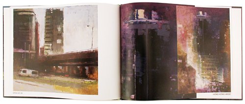 An open art book or magazine showing two painted cityscape pages side by side. The left page depicts a street scene with tall buildings and a bridge under a pale sky, while the right page shows a darker, moody city painting with purple, black, and warm light tones.