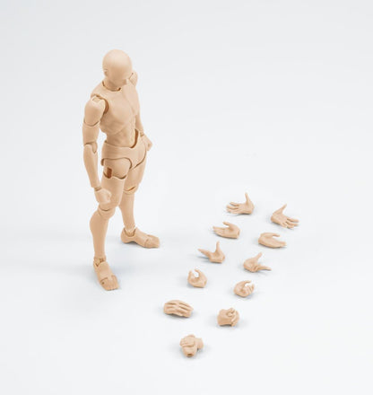 A beige plastic articulated human figure with multiple interchangeable hands displayed beside it on a clean white studio background.