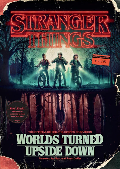Cover of the book 'Stranger Things: Worlds Turned Upside Down,' featuring three characters from the series with a dark, foreboding atmosphere in a forest setting.