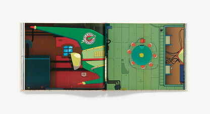 An open illustrated book or art print showing a stylized interior scene with a green floor, red and teal furniture-like forms, and small circular details, photographed against a plain light background.