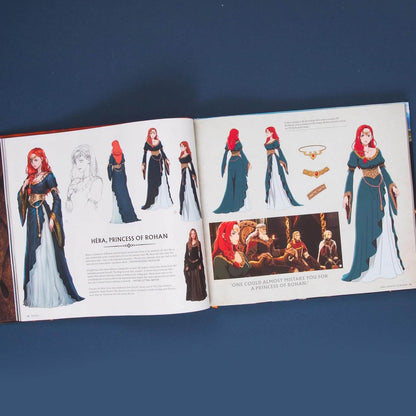 An open art book or costume design book laid flat on a dark blue background, showing character sketches and illustrations of a fantasy woman labeled 'Hera, Princess of Bohan' with multiple costume variations and a small scene panel.