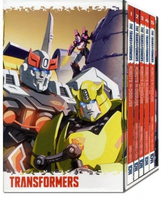 Transformers box set with a large illustrated cover showing robot characters and the title 'TRANSFORMERS,' plus a row of red-and-white boxed volumes on the right.