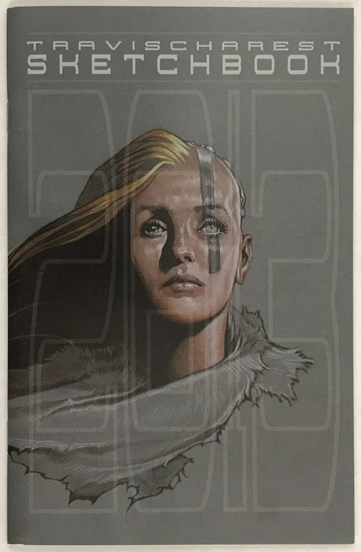 Travischarest Sketchbook featuring a stylized sketch illustration of a woman's face with blonde hair and a gray scarf, set against a dark gray background with the title text at the top.